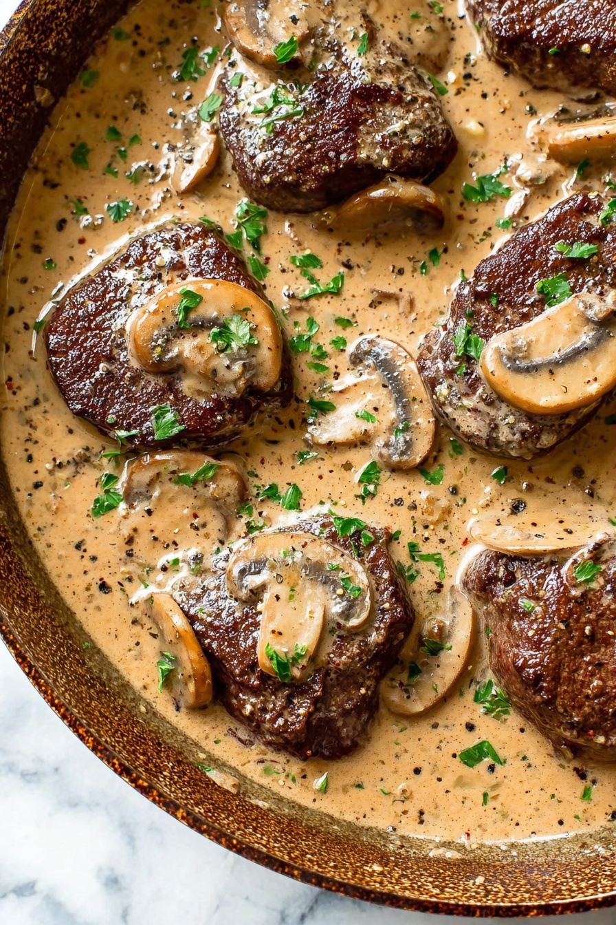 The image shows a white pan filled with four pieces of dark brown meat partially covered in thick, creamy light brown mushroom sauce with visible slices of mushrooms. The sauce has specks of black pepper and green chopped herbs sprinkled on top and around the meat. A large metal spoon rests on the right side of the pan, and the pan is placed on a white marbled surface with a light beige cloth underneath. A white plate with scattered green herbs is partially visible in the top left corner. Photo taken with an iphone --ar 2:3 --v 7